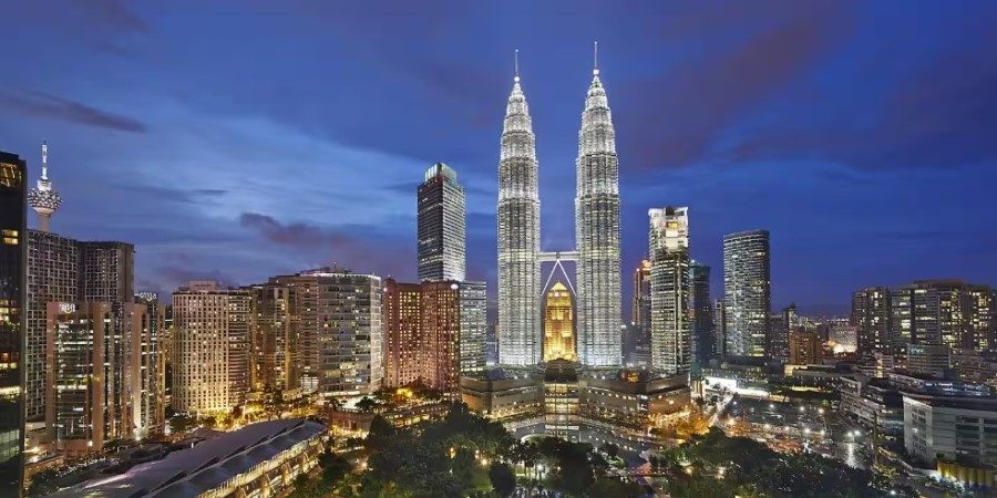 Night view of the Petronas Towers, beautifully lit, highlighting their iconic design in the Kuala Lumpur skyline.